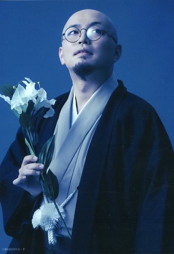 熊野利哉(種田山頭火)/上半身・キャラクターショット・衣装黒・グレー・白・右手に花・視線右上・背景青/舞台「文豪ストレイドッグス 黒の時代」ランダムブロマイド