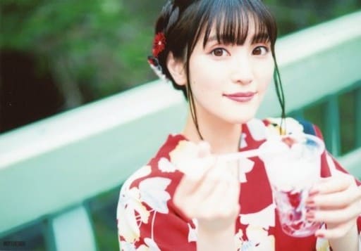 Koga Aoi in a red yukata holding a dessert with her left hand, and passing a scooped serving with her right