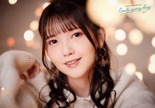 Kitou Akari wearing a long-sleeved knitted top, smiling and surrounded by decorative mini-LED lights