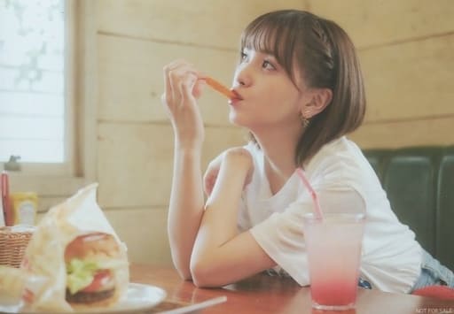 Kitou Akari eating a potato fry looking top right out of the window, sitting in a fast food restaurant with a burger on a plate placed away from her
