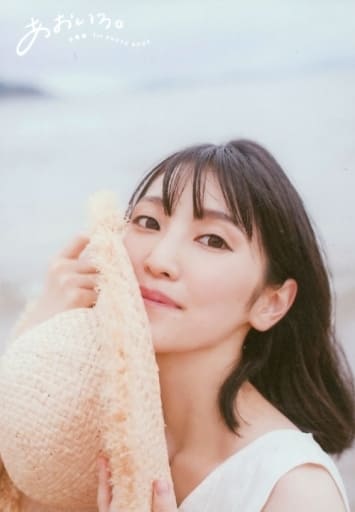 Koga Aoi at the beach in a white dress, right cheeck against a sunhat looking back